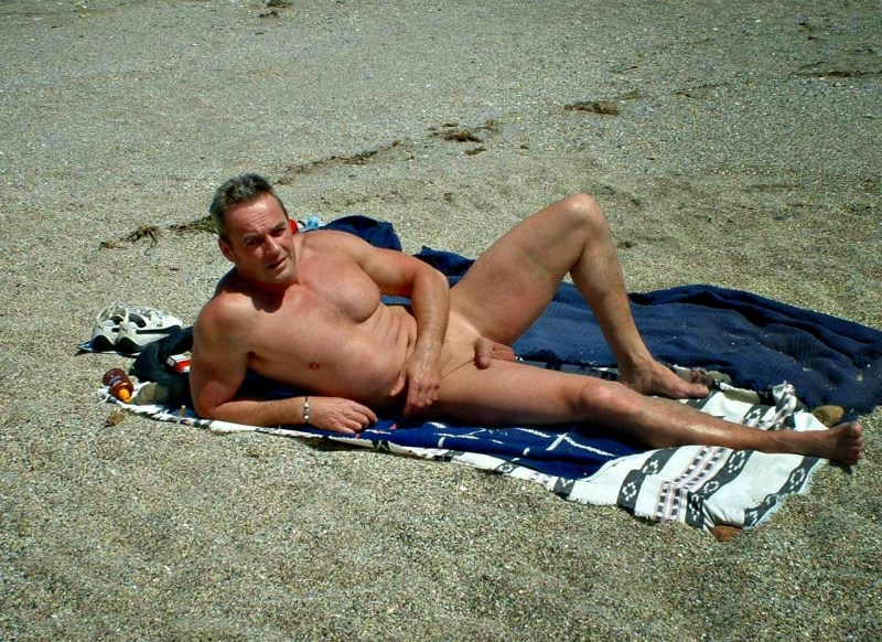 Naked guy with an erection on the beach