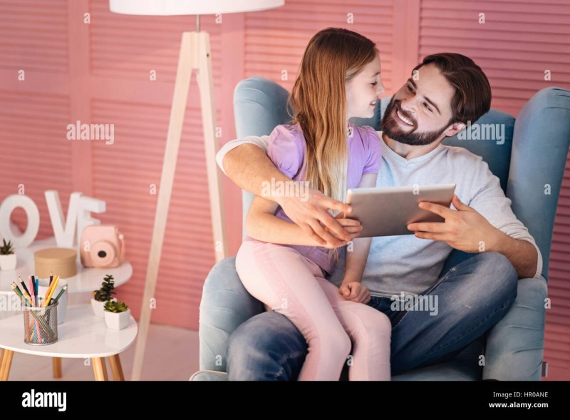 Girl sits on her father's knees