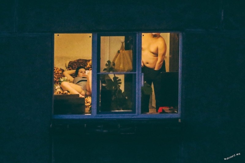 The girl undresses in front of the window