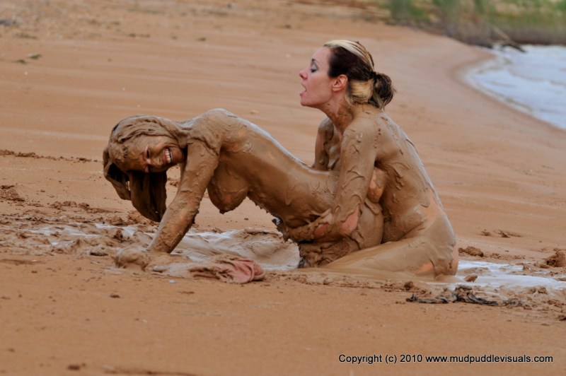 Naked women are lying in mud