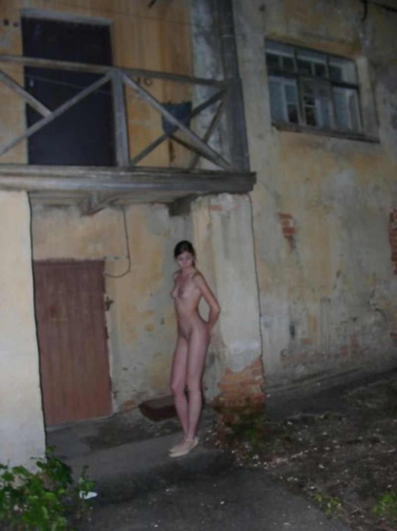 The girl undresses in the yard