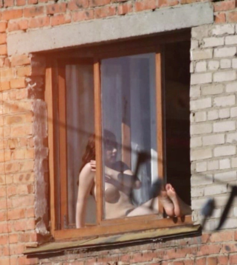 Naked women in the windows of houses