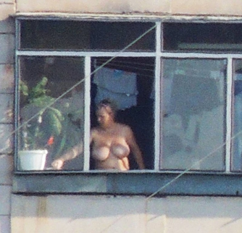 Naked women in the windows of houses
