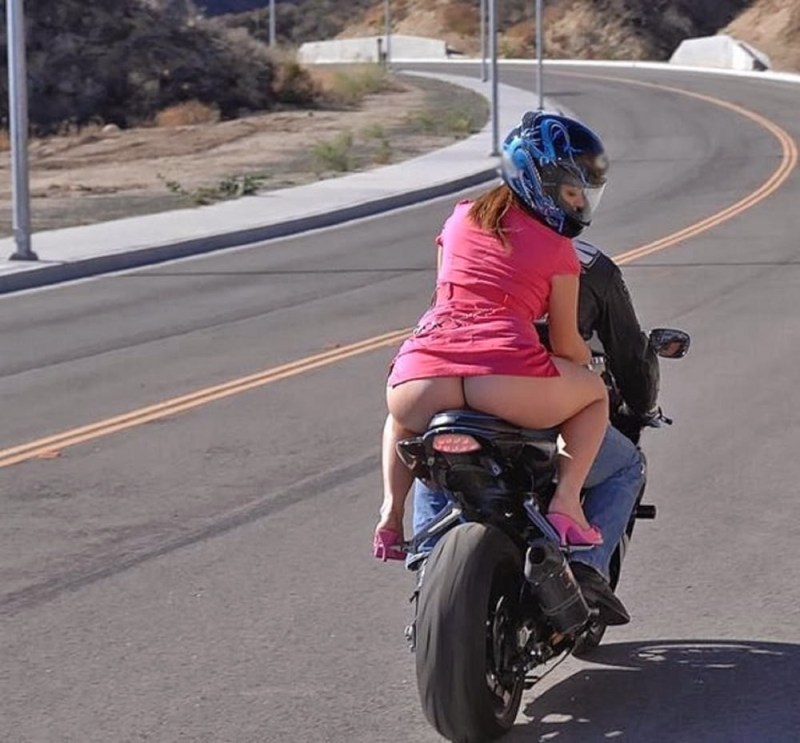 The girl rides on a motorcycle without panties