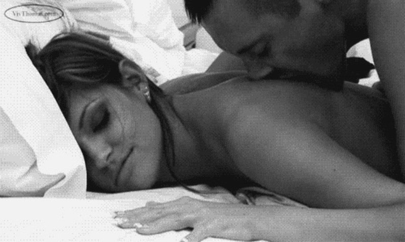 The guy caresses the girl in bed