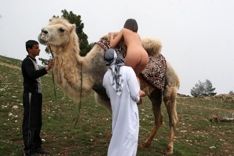 Naked with a camel in the desert