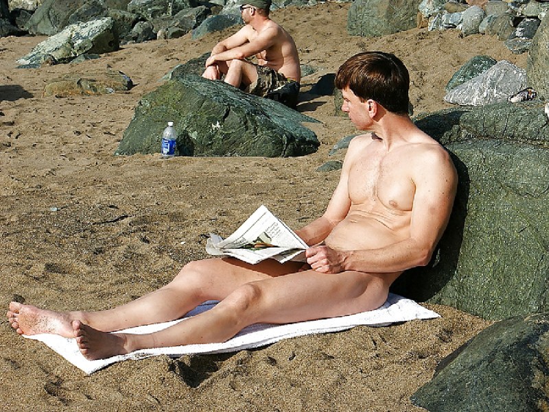 Naked men sunbathe on the beach