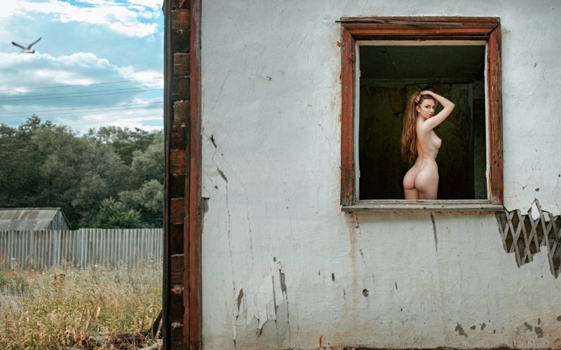 Naked women in the windows of houses
